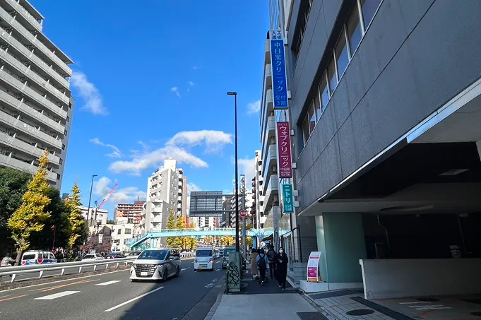 頭上にピンク色のウォブクリニック看板があるビル